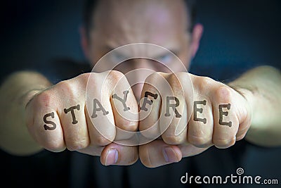 STAY FREE written on an angry manâ€™s fists Stock Photo